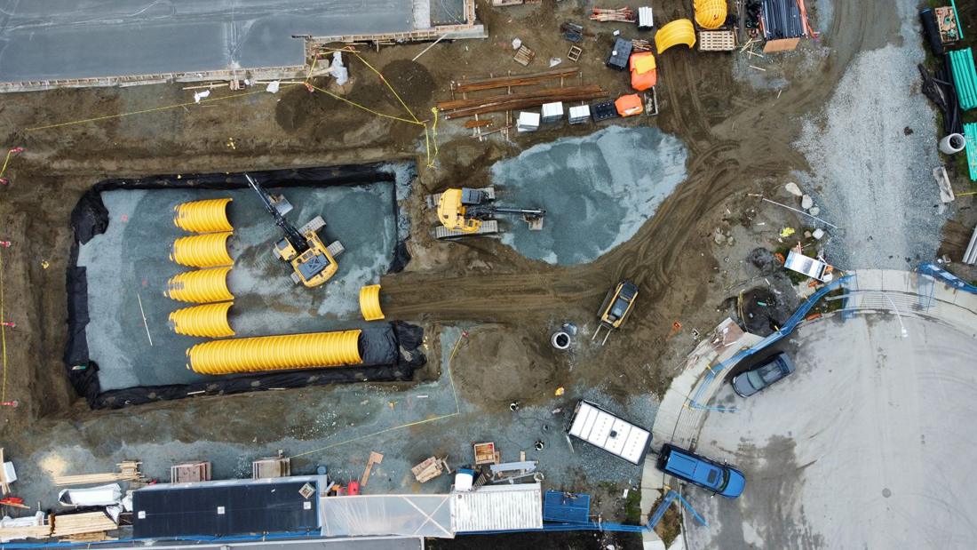 Top-down drone view of a stormwater detention chamber system in an excavation