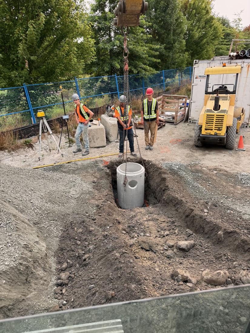 Crew working together around a newly set manhole